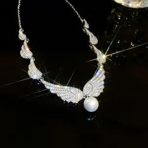 Detailed close-up view of a sparkling silver wing necklace featuring a large white pearl pendant