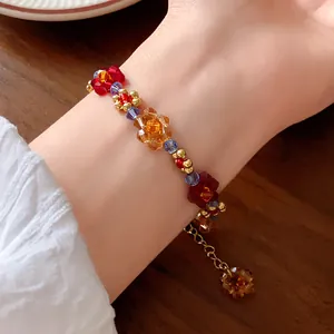 Dettaglio ravvicinato di un colorato braccialetto di fiori di perline stile dopamina al polso.