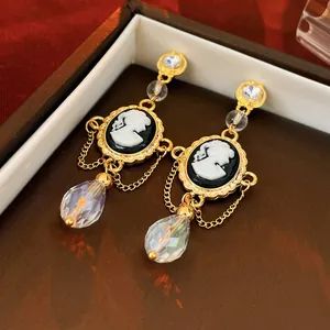 Elegant vintage style cameo earrings with gold chains and iridescent crystal drops