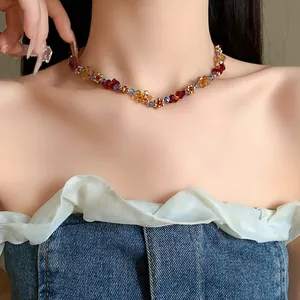 Elegante collana di perle colorate con motivo floreale indossata da una modella chic.