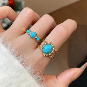 Detalle de dos anillos abiertos vintage chapados en oro de 18 quilates con turquesas
