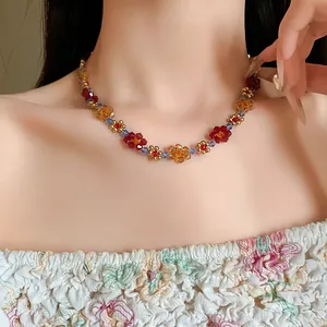 Dettaglio di una collana di fiori di perline colorate indossata da una modella stile foresta.