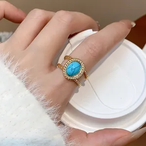 Primer plano de un anillo ajustable bañado en oro 18k con piedra turquesa vintage