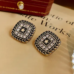 Close-up of vintage square stud earrings featuring a star motif and crystal rhinestones
