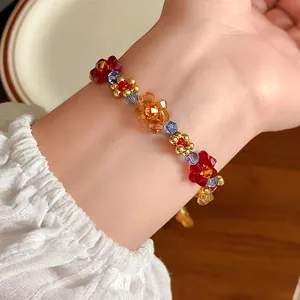 Dettaglio in primo piano di un braccialetto di fiori di perline colorate al polso