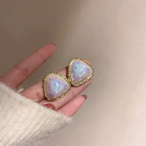 Detailed view of elegant irregular geometric earrings with a shimmering pearlescent center