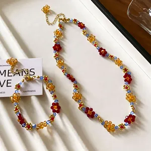 Primo piano di collana e braccialetto colorati con fiori di perline dopamine su vassoio