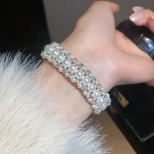 Primo piano di un elegante bracciale in stile francese con perle e strass brillanti.
