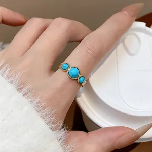 Primer plano de anillo turquesa bañado en oro de 18 quilates en el dedo