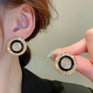 Close-up detail showing the texture of vintage black and gold rhinestone stud earrings