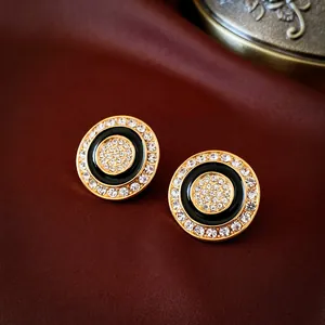 Vintage black enamel stud earrings featuring shimmering crystal accents and golden trim