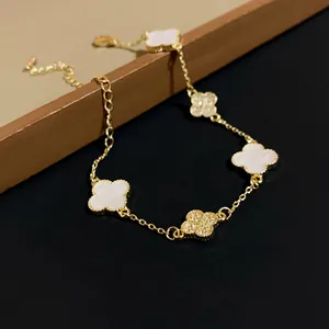 Detailed shot of a gold-plated bracelet featuring white acetate and stone-set clovers