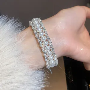 Elegante bracciale multifila di perle e strass in stile francese, vista dettagliata al polso