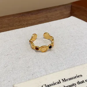 Detalle del anillo abierto vintage chapado en oro de 18 quilates con piedras incrustadas.