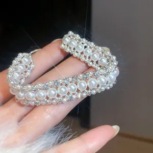 Primo piano del bracciale di perle stile francese con strass luccicanti indossato sulla mano