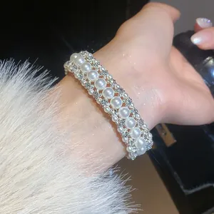 Dettaglio ravvicinato di un elegante braccialetto di perle a tre file con strass brillanti
