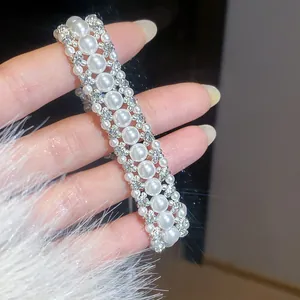 Macro di un elegante bracciale a tre file di perle con dettagli in strass scintillanti