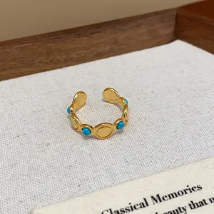 Primer plano de anillo abierto vintage bañado en oro 18k con piedras turquesas