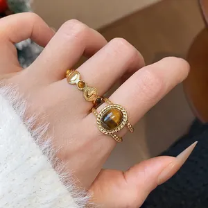 Vista detallada de anillos vintage bañados en oro de 18K con piedras de ojo de tigre