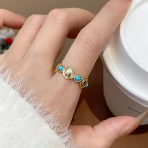 Detalle de cerca de un anillo abierto de oro de 18 quilates con piedras verdes vintage