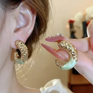 Elegant mint green enamel C-shaped hoop earrings with gold textured wrinkled design.