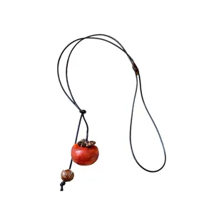 Collana artigianale con ciondolo in legno a forma di cachi e perline su corda cerata