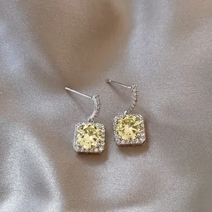 Close-up of elegant square yellow zircon drop earrings with 18K gold plated silver needles