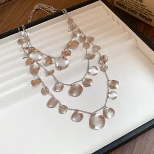Detailed view of silver triple-layered necklace with textured crumpled circular pendants.