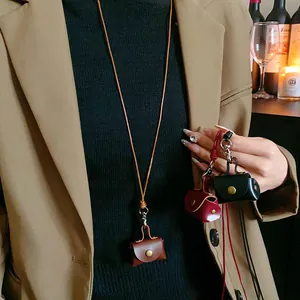 Detailed view of handmade leather mini pouch necklaces in brown, red, and black.