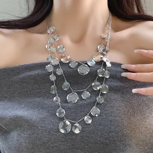 Detail showing textured hammered round discs on a layered silver-tone necklace.