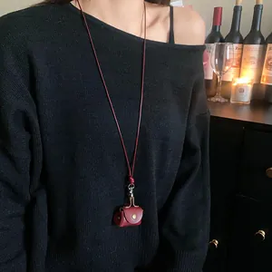 Vintage dark red leather mini pouch sweater necklace worn over a cozy black knitted top