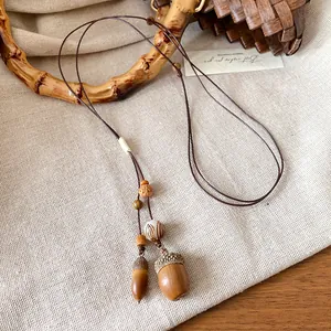 Vista macro dettagliata della collana artigianale con ciondolo a ghianda e corda cerata