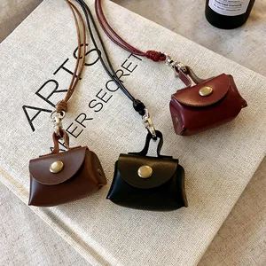 Detailed view of three mini leather coin pouch necklaces in brown black and deep red colors