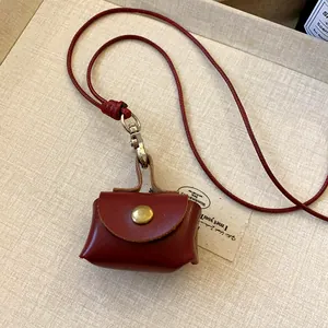 Detailed close-up of vintage red leather mini earphone pouch on a matching neck cord