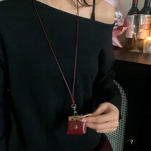 Close-up view of a retro dark red leather earphone pouch worn as a stylish neck lanyard