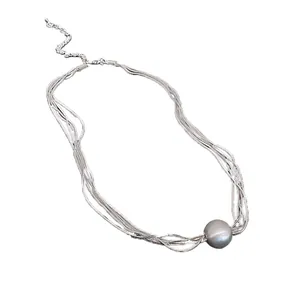 Elegant silver multi-strand necklace featuring a large matte round bead pendant design