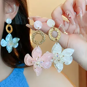 Detailed macro view of resin flower pendant earrings in pink and white floral design