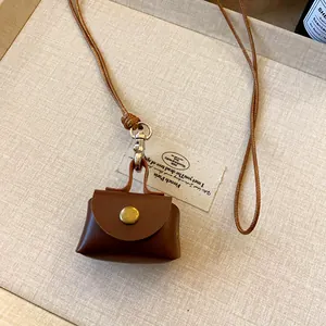 Detailed view of a brown leather coin pouch necklace with a snap button closure.