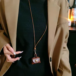 Close-up of a vintage brown leather earphone pouch worn as a stylish necklace