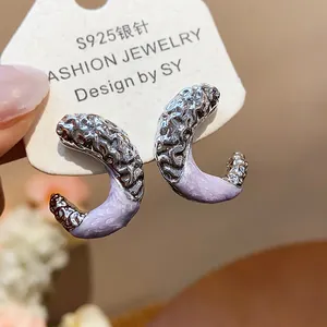 Detailed macro view of lavender enamel C-shape earrings with hammered silver pleated texture
