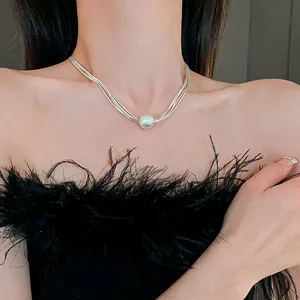 Elegant multi-strand silver necklace featuring a large round pearl pendant detail view.