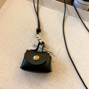 Detailed macro view of vintage black leather mini coin bag pendant with gold snap button