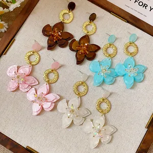 Detailed close-up of vintage resin flower dangle earrings in four elegant colors with gold rings