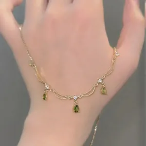 Élégant collier plaqué or 18 carats avec pendentifs en zircone verte et design à franges.
