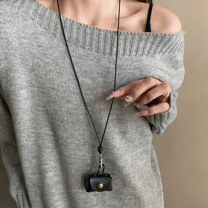 Detailed view of a retro black leather pouch necklace worn as a chic sweater chain accessory.