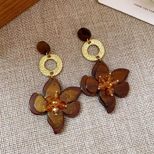 Detailed view of vintage resin flower drop earrings with tortoiseshell finish and crystals.