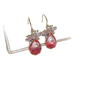 Elegant gold hook earrings featuring pink teardrop zircons and flower motif.