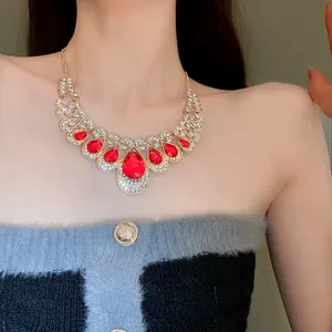 Close-up of statement gold necklace with red water drop stones and rhinestones