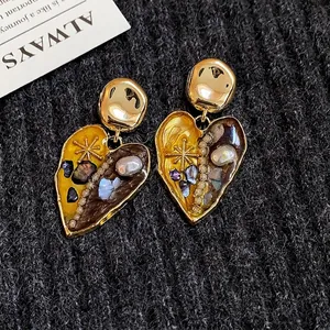 Orecchini a cuore vintage con perle e finitura dorata su elegante sfondo a maglia