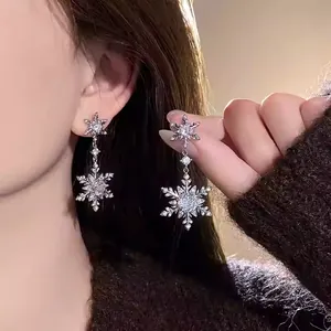 Sparkling snowflake dangle earrings with zircon crystals for elegant winter style.